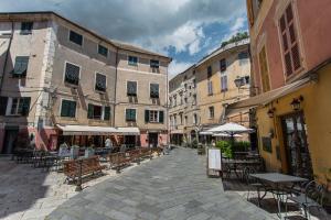 una calle vacía con mesas, sillas y edificios en Antico Pozzo Bed and Breakfast, en Finale Ligure