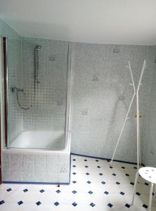 uma casa de banho com um chuveiro e uma banheira com piso em azulejo em Haus am Oberen Mühlenberg mit GARTENNUTZUNG em Monschau