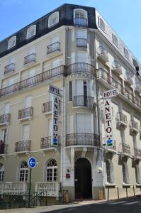 a building with signs on the side of it at Hôtel Aneto in Lourdes