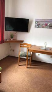 a room with a table and a chair and a television at Zielitzer Hof in Zielitz