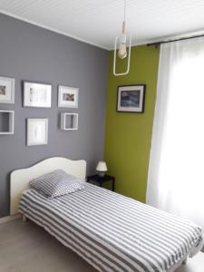 1 dormitorio con cama y pared verde en Les portes du soleil en Les Sables-dʼOlonne