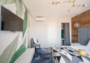 White Villas Koblevo في كوبليفو: غرفة نوم بسرير وتلفزيون على جدار