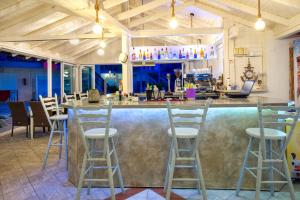 un bar en un restaurante con taburetes alrededor en Hotel Marialena en Potos