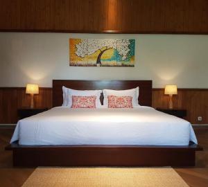 um quarto com uma cama grande e 2 candeeiros em Villa Aquin em Surakarta