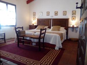 - une chambre avec un lit, une table et une chaise dans l'établissement Casa Rural y Restaurante Casa Adriano, à Alanís