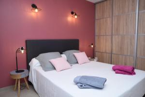 a bedroom with a large white bed with pink pillows at Gite Les Lavandes in Vaison-la-Romaine