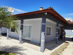 una pequeña casa con un garaje con una palmera en Casa Praia Alegre, en Penha