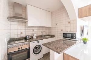 a white kitchen with a washer and a sink at Calas Beach Corralejo in Corralejo