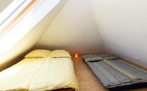 Duas camas num pequeno quarto com uma janela em Idylisches Ferienhaus komplett im Grünen mit direkter Anbindung an den Thayatalradweg em Vestennötting