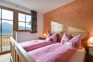 - une chambre avec 2 lits et des oreillers roses dans l'établissement Apartement Vorderlaiming, à Söll