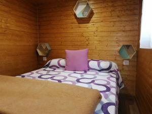 Habitación pequeña con cama con almohada morada en Camping La Ribera Salada, en 