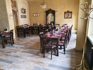 a dining room with tables and chairs with pink plates on them at Hotel Fontana in Novi Sad