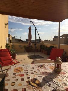 een patio met een tafel en stoelen en een parasol bij Il Terrazzo del Pittore in Mazara del Vallo