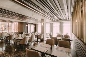 a restaurant with tables and chairs in a room at Imperia Apartments in Vrnjačka Banja