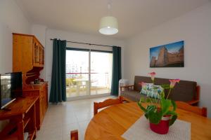a living room with a table and a couch at Casa Canoa B in Armação de Pêra