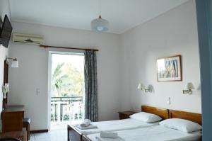 Habitación de hotel con 2 camas y ventana en Paradise Beach Apartments en Argasi