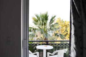 a balcony with a table and a palm tree at Paradise Beach Apartments in Argassi