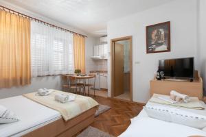 a small room with two beds and a kitchen at Apartments Barba in Tučepi