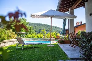 patio con tavolo, ombrellone e piscina di J&J House a Castelmarte
