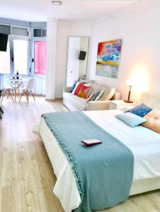 um quarto com uma cama grande e uma sala de estar em Cosy loft in front of blue ocean em Las Palmas de Gran Canaria
