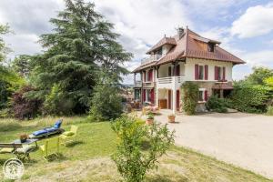 Uma casa velha com uma carroça à frente. em VILLA SERANDITE maison de famille em Annecy