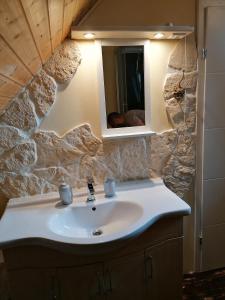 a bathroom with a sink and a stone wall at Haus Daniela in Klagenfurt