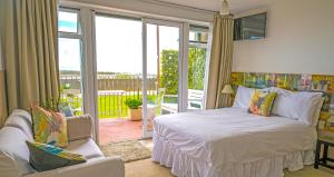 a bedroom with a bed and a balcony at Bayview Bed and Breakfast in Stonehaven