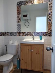 a bathroom with a toilet and a sink and a mirror at Marina Beach-Apartamentos Tahiche in Costa Teguise