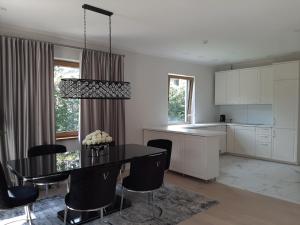 a kitchen and dining room with a table and chairs at Mazoji vila in Birštonas