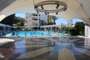 a pool at a resort with blue chairs at Hotel Mirasole International in Gaeta