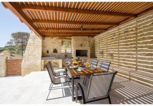 a dining room with a table and chairs on a patio at Villa Arietta in Kharkhalianá