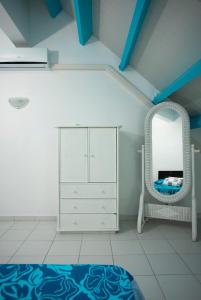 ein Schlafzimmer mit einer weißen Kommode und einem Spiegel in der Unterkunft FRAICHEUR DES CARAIBES in Saint Martin