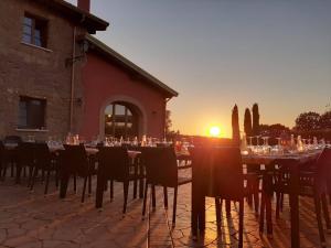 a tables and chairs with the sunset in the background at Agriturismo Podere Del Lepre in San Quirico