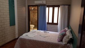 a bedroom with a bed in a room with a window at GUEST HOUSE LA MANSIÓN in Foz do Iguaçu