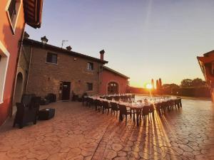 un groupe de tables et de chaises devant un bâtiment dans l'établissement Agriturismo Podere Del Lepre, à San Quirico