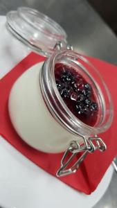 a glass jar of jam on a red and white plate at Agriturismo Podere Del Lepre in San Quirico