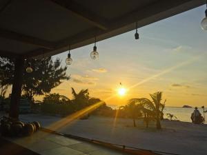 a view of the sunset from a beach with lights at Ocean Vista Maldives,Maafushi in Maafushi