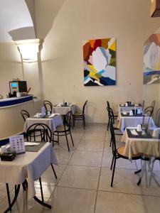 un restaurante con mesas y sillas y una pintura en la pared en Hotel Venezia, en La Spezia