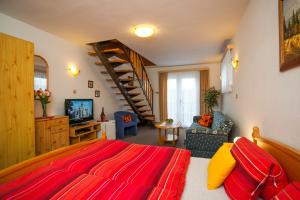 1 dormitorio con cama roja y sala de estar en Pension Minor, en České Budějovice