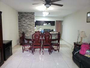 una sala da pranzo con tavolo, sedie e divano di Departamentos Mazatlán a Mazatlán