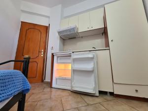una piccola cucina con frigorifero aperto e porta di Gallery ad Ammouliani