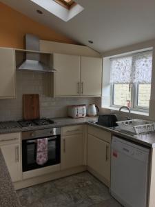 a kitchen with white cabinets and a stove top oven at Primrose in Shrewsbury