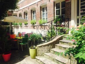 een patio met een trap en een tafel en stoelen bij Le Pavillon Hotel in Parijs