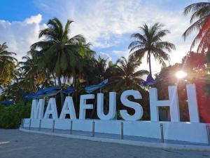 um grande sinal com palmeiras no fundo em Ocean Vista Maldives,Maafushi em Maafushi