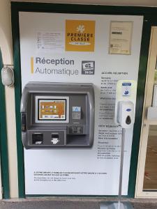 una máquina atm en el lateral de una pared en Premiere Classe Coulommiers Mouroux, en Mouroux