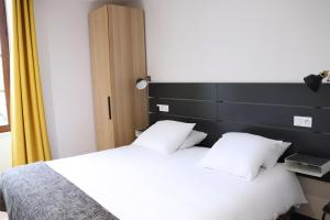 a hotel room with a bed and a lamp at Hotel Athanor Centre in Beaune