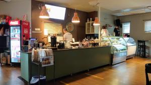 a restaurant with a counter with people preparing food at Hanne North Guest Studios in Skjervøy