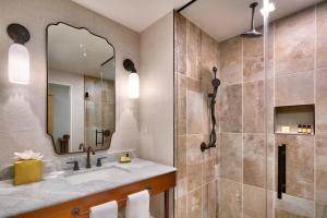 a bathroom with a mirror, sink, and bathtub at The Advenire, Autograph Collection in St. George