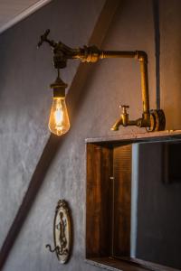 ein Licht hängt an einer Wand neben einem Spiegel in der Unterkunft Storchennest Sankt Annen in Annaberg-Buchholz
