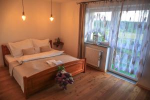 a bedroom with a bed and a large window at Agroturystyka Sikorki in Lubomierz